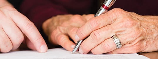 Hands writing on a document