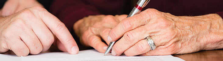 Hands writing on a document