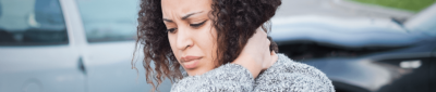 injured woman holds her neck outside of a car accident