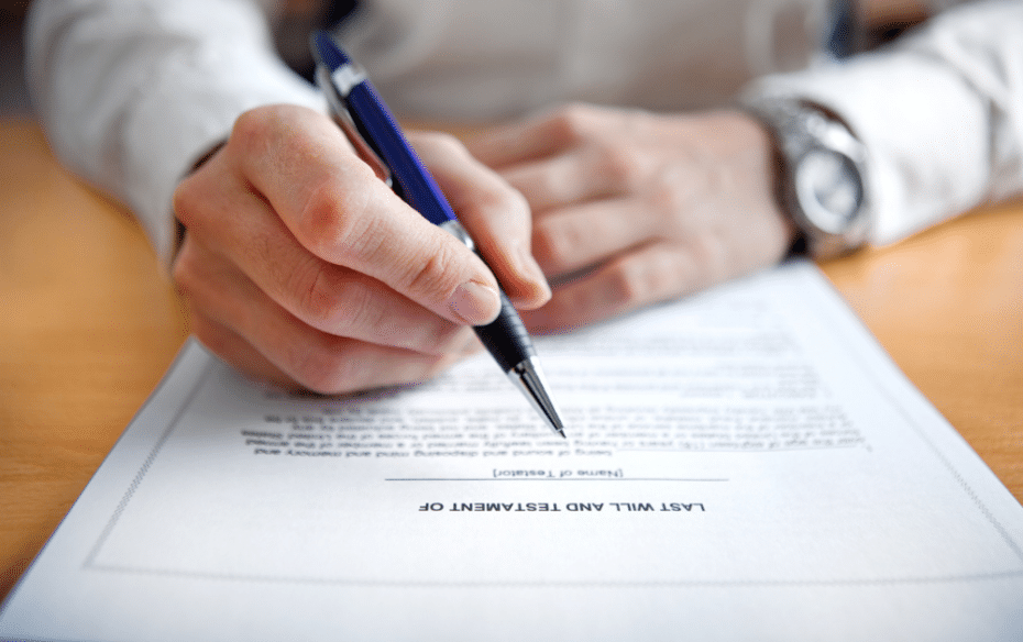 An estate lawyer holds a pen above a will