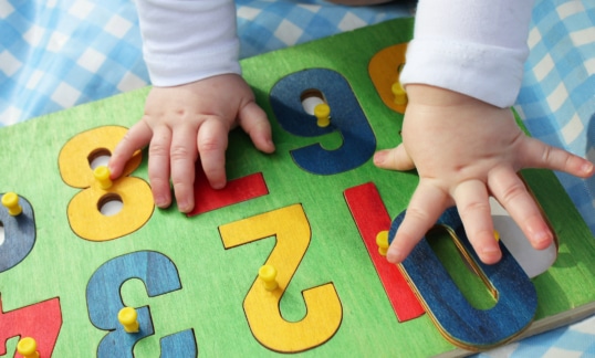 A young child infant playing with a number puzzle
