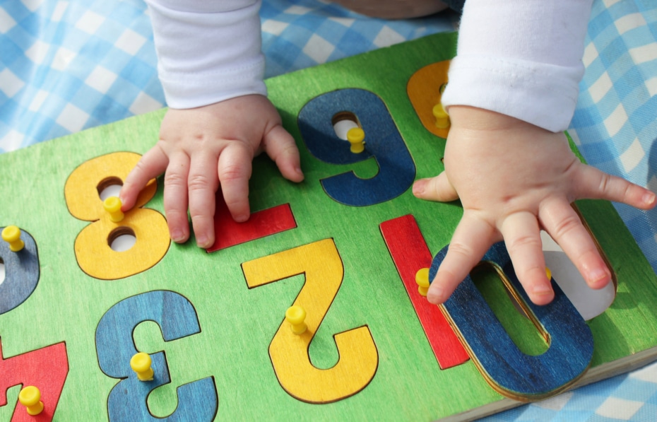 A young child infant playing with a number puzzle