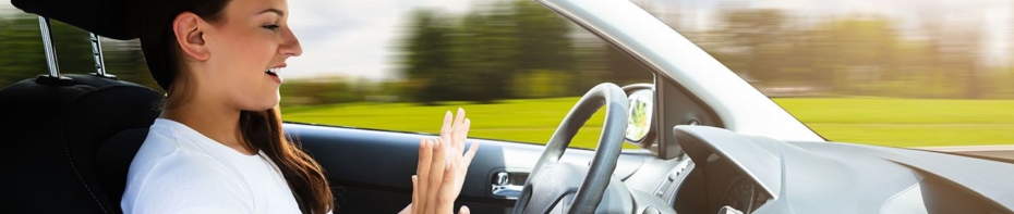 Person behind the wheel of an autonomous vehicle with their hands off the wheel.