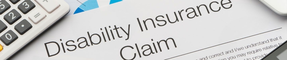 Close up image of Disability Insurance Claim paperwork with calculator and pen.