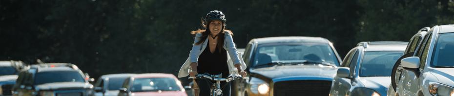 Woman on bike along busy street