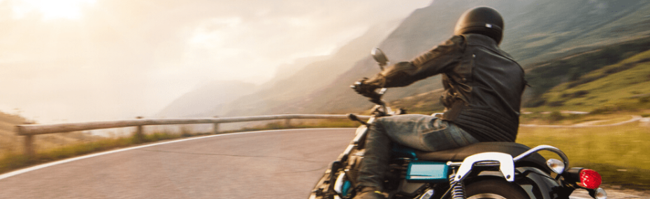 A man on a motorbike driving down a windy road