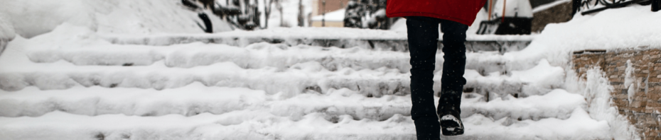 A woman walks up icy, slippery stairs