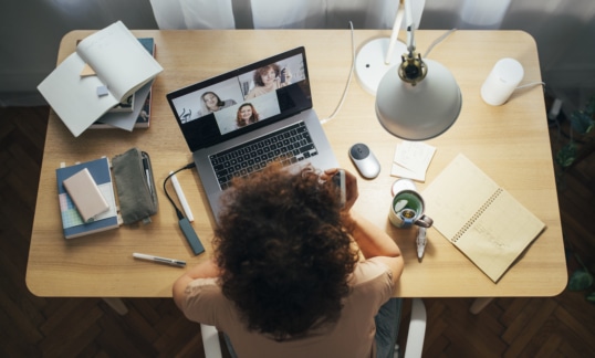 Woman sits at desk of home office