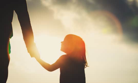 Little girl holding parent's hand