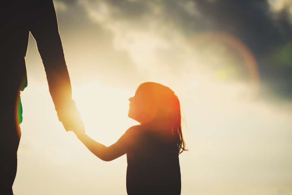 Little girl holding parent's hand