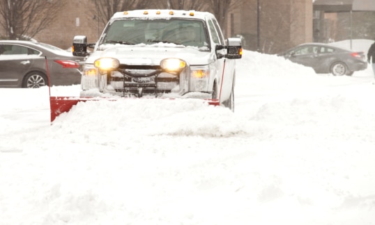 Snow plow removing snow at an apartment complex