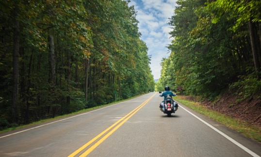 Motorcycle on the road with trees in the summer