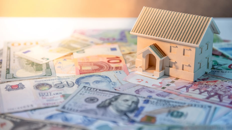 Wooden house model on a floor of money