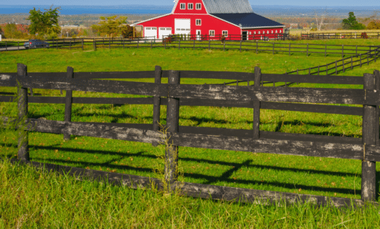 Red farmhouse amongst a green field.